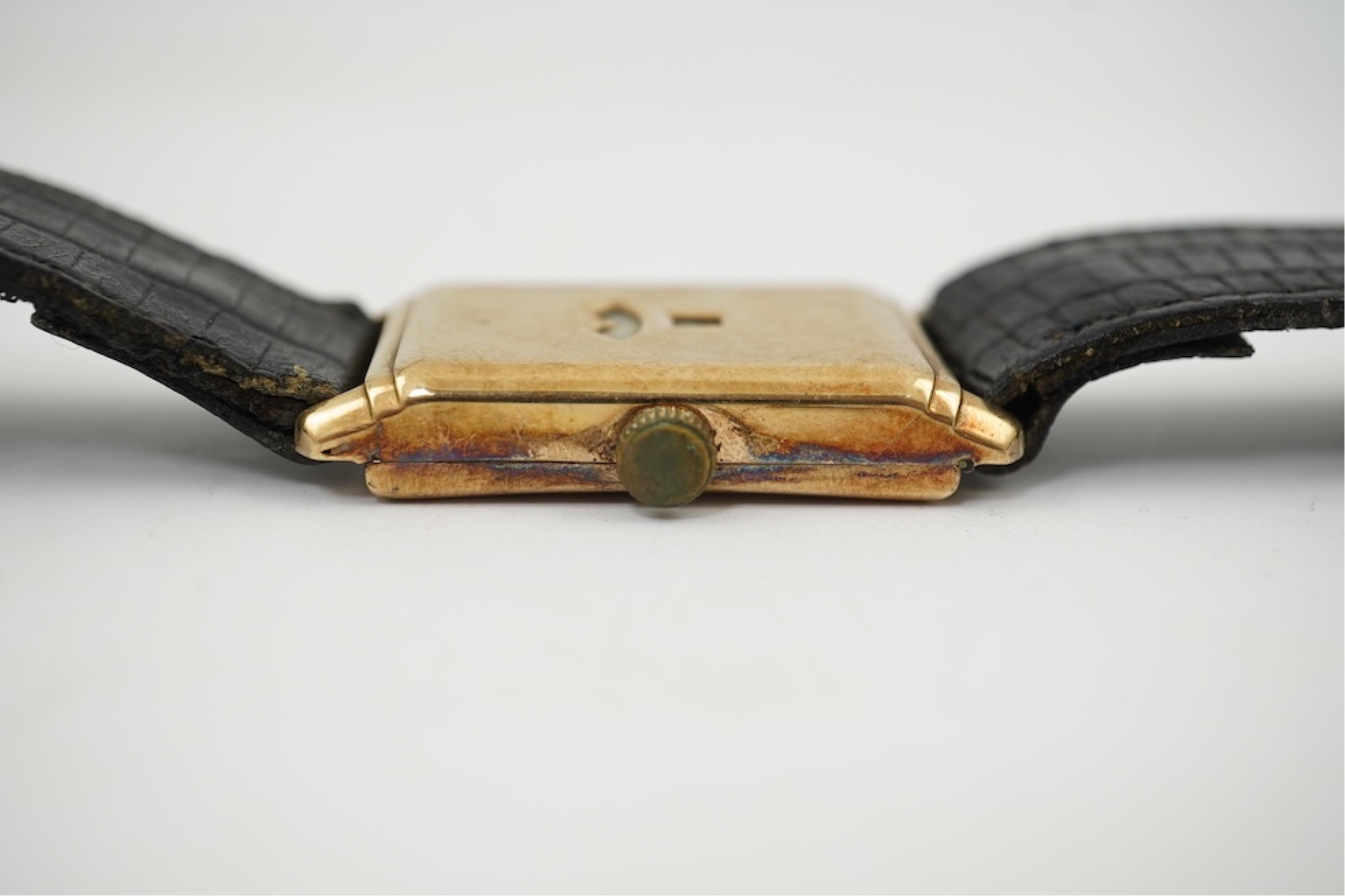 An early 1930's 9ct gold Swiss 'Jump Hour' rectangular cased manual wind wrist watch, case diameter 20mm, on a leather strap, gross weight 23 grams.